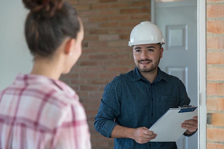 Contractor with clipboard meeting homeowner